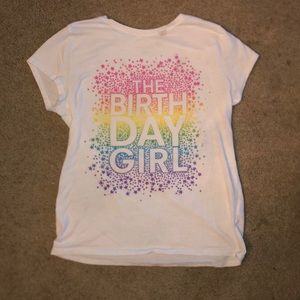 “The birthday girl” is what it says. Size 10-12